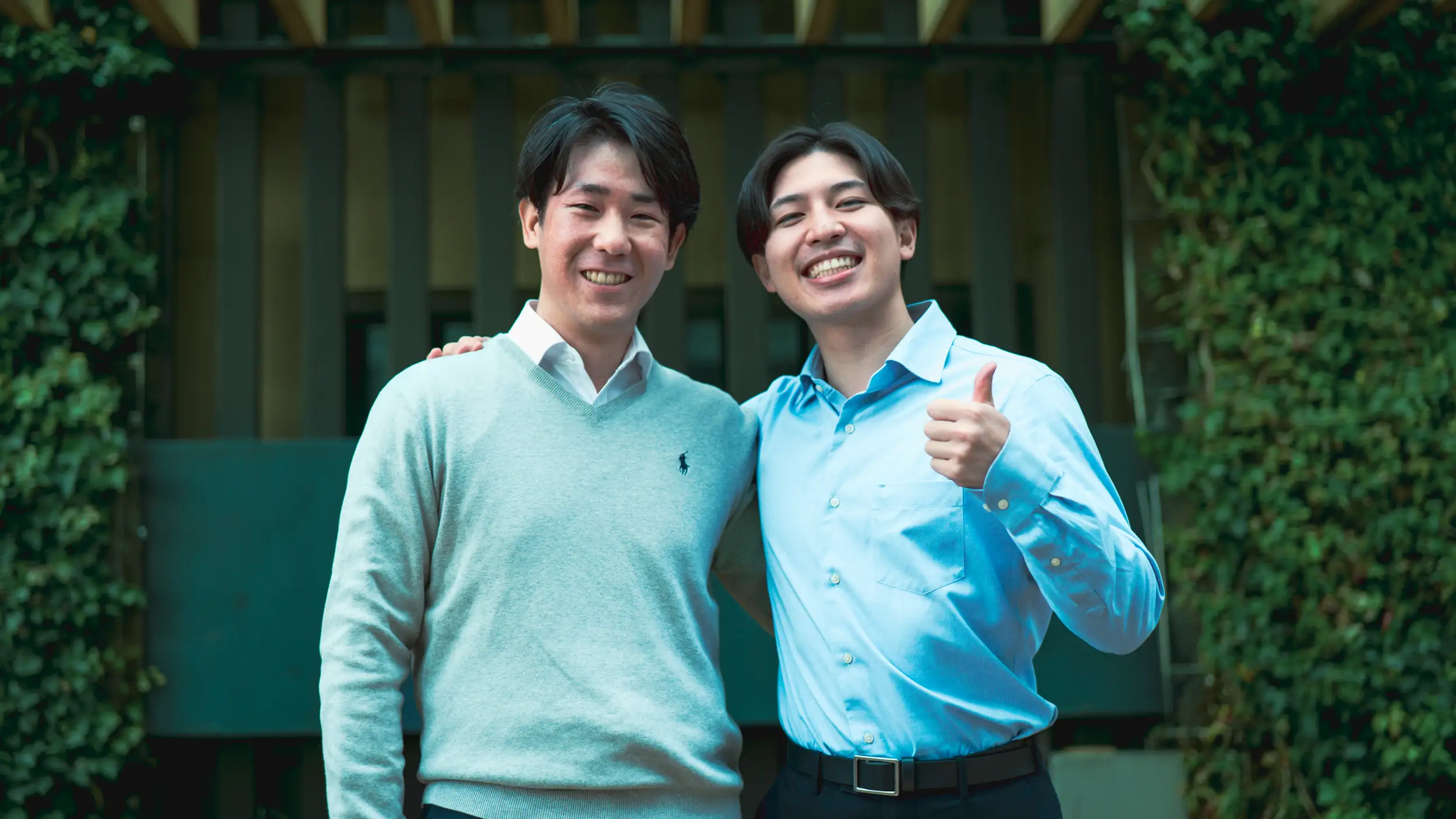 社員達が笑顔で肩を組んでいる写真